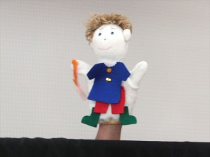 今月のおたのしみは人形劇。青いシャツと赤いズボン、傘と長靴がお似合いだね。